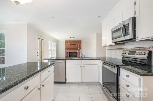 a kitchen with stainless steel appliances granite countertop a sink and a stove