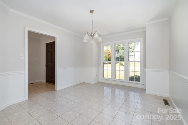 an empty room with windows and chandelier