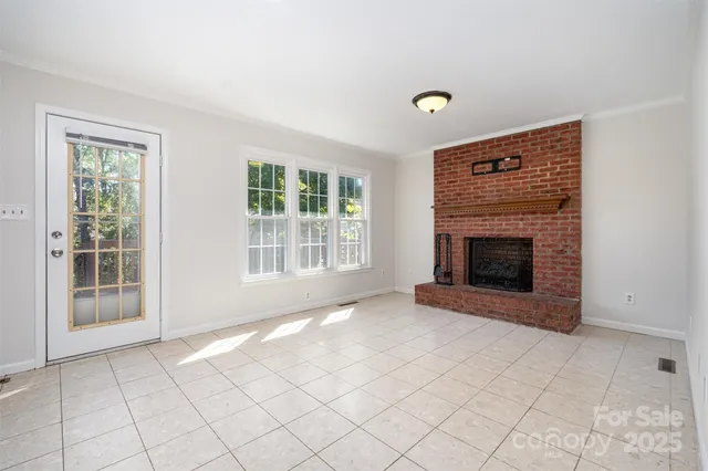 a view of an empty room with a fireplace and a window