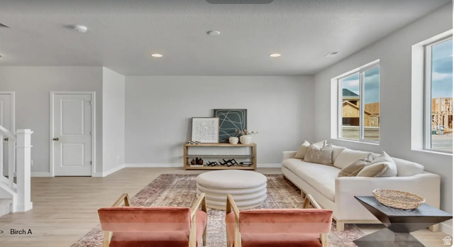 2184 West 2575th North, Unit 125 Clinton, UT 84015 - Photo 2 of 5 Spacious living area featuring light wood-finish flooring, recessed lighting, and ample natural light from multiple windows