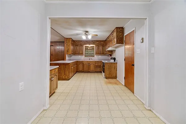 a kitchen with cabinets and wooden floor