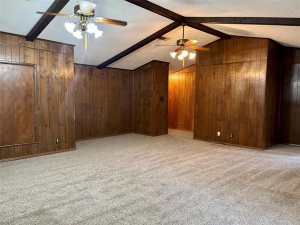 a view of an empty room with a chandelier fan