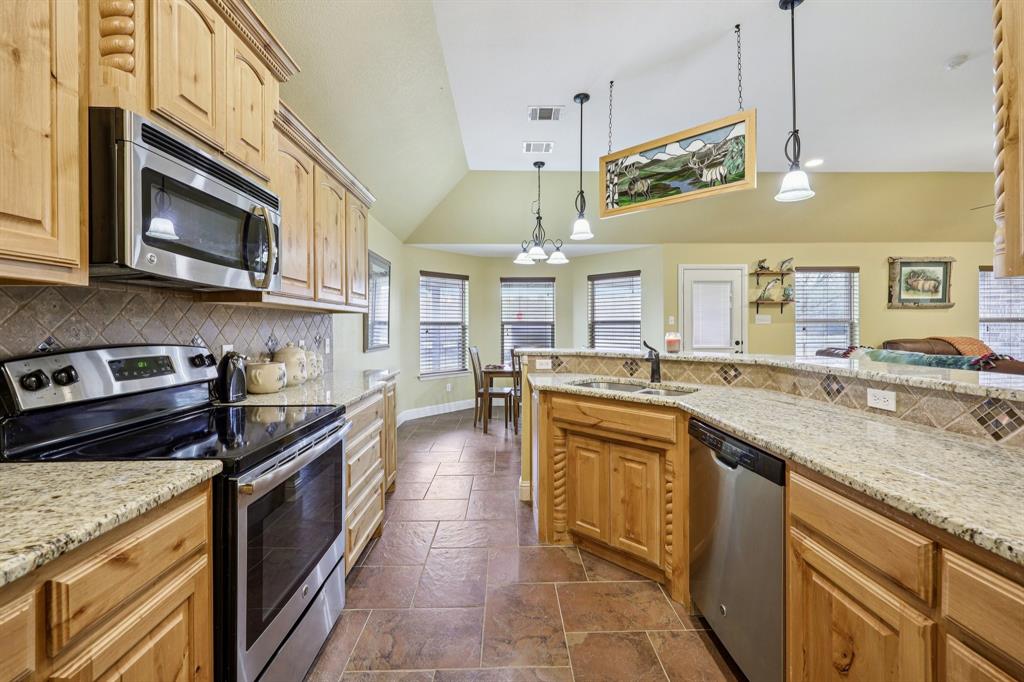 118 Kenya Court Springtown, TX 76082 - Photo 13 of 35 a kitchen with stainless steel appliances granite countertop a stove a sink and a microwave