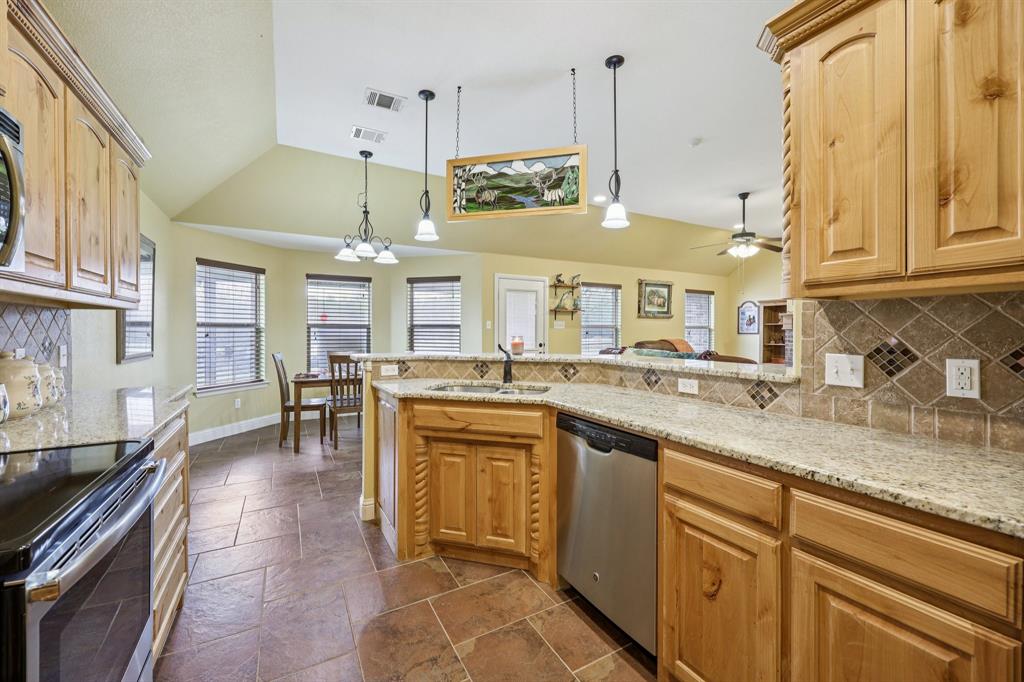 118 Kenya Court Springtown, TX 76082 - Photo 14 of 35 a kitchen with stainless steel appliances granite countertop a sink a stove counter space and cabinets