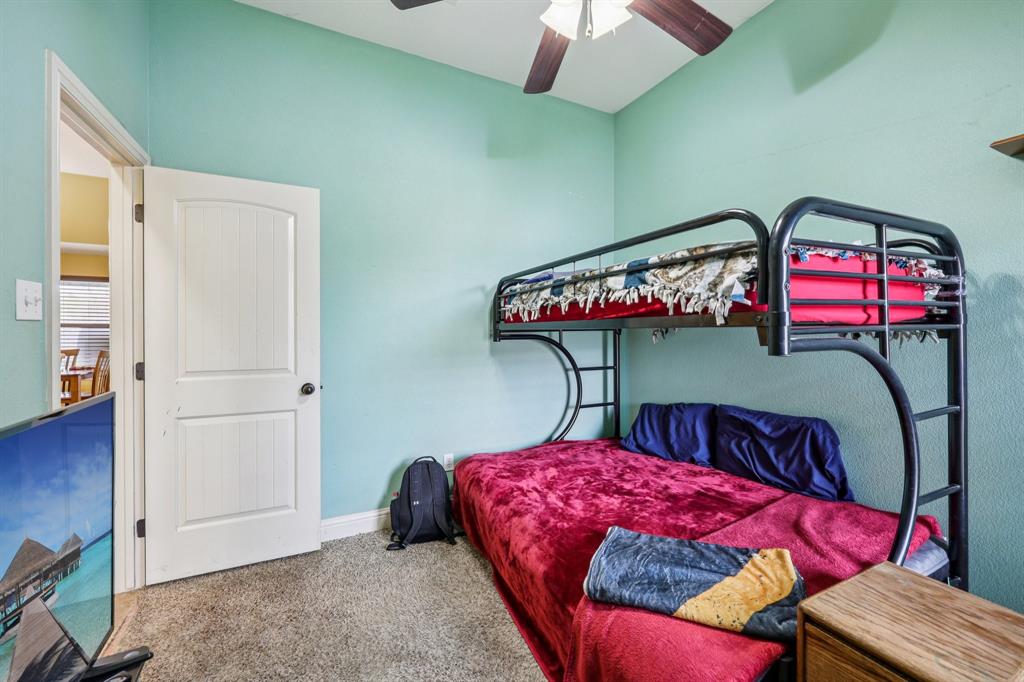 118 Kenya Court Springtown, TX 76082 - Photo 17 of 35 a bedroom with a bed a chandelier and dresser