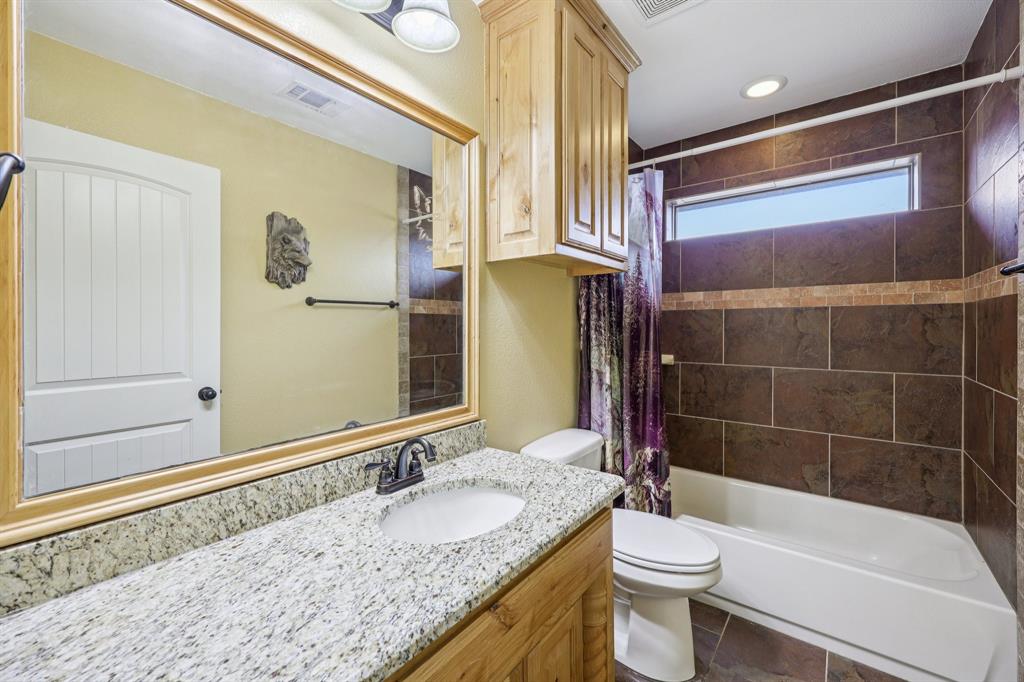 118 Kenya Court Springtown, TX 76082 - Photo 18 of 35 a bathroom with a granite countertop sink toilet and shower