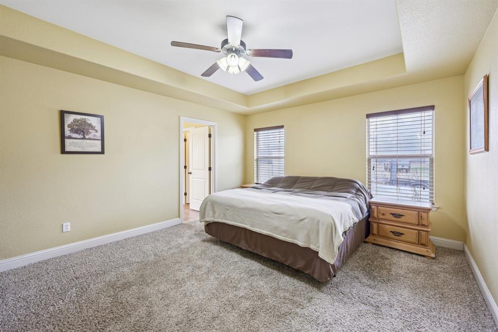 118 Kenya Court Springtown, TX 76082 - Photo 23 of 35 a spacious bedroom with a bed and a ceiling fan
