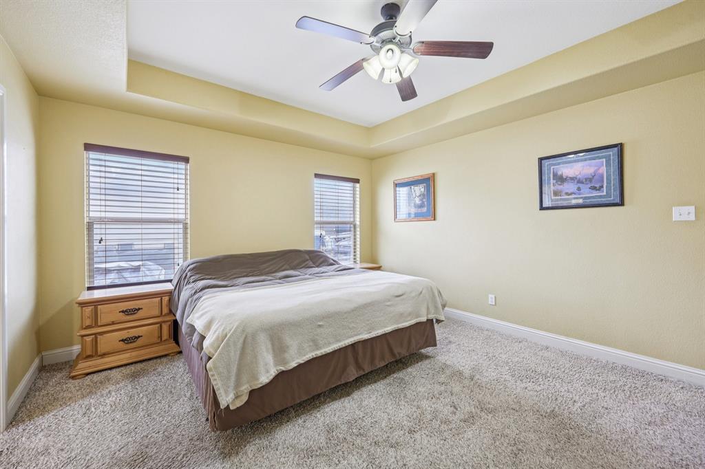 118 Kenya Court Springtown, TX 76082 - Photo 26 of 35 a bedroom with a bed and a chandelier