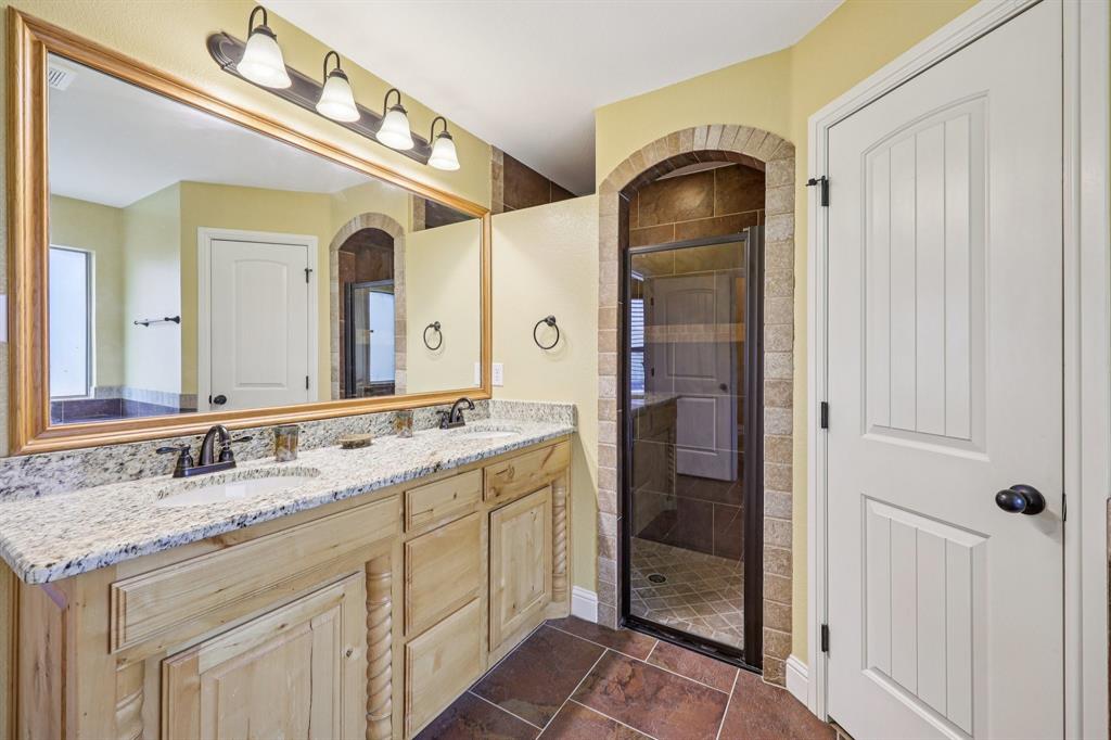 118 Kenya Court Springtown, TX 76082 - Photo 27 of 35 a bathroom with a granite countertop double vanity sink and mirror