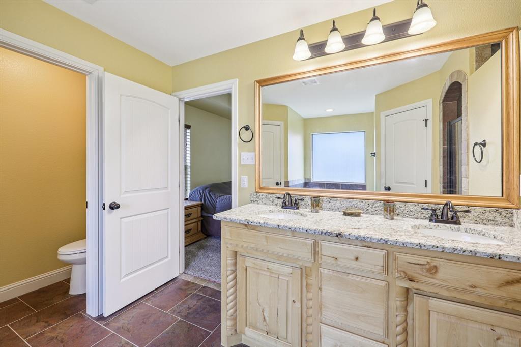 118 Kenya Court Springtown, TX 76082 - Photo 29 of 35 a bathroom with a granite countertop sink and a mirror