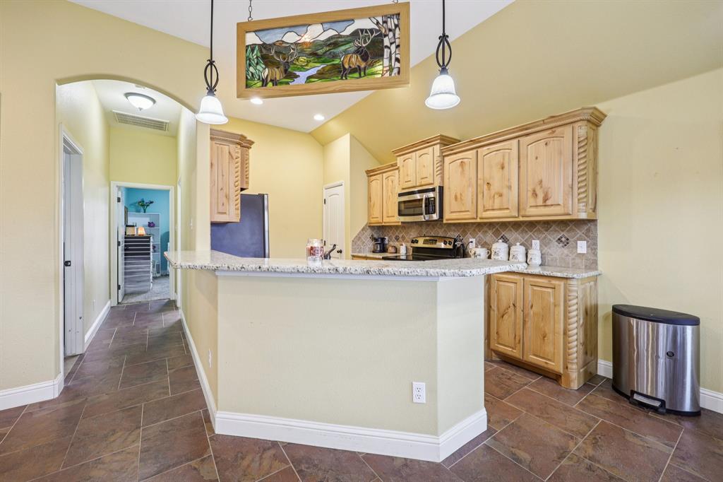 118 Kenya Court Springtown, TX 76082 - Photo 10 of 35 a kitchen with stainless steel appliances granite countertop a refrigerator a stove and a sink