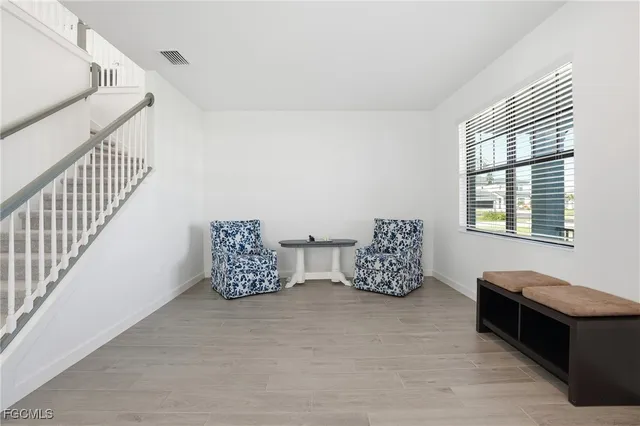 a room with lots of white furniture and a window