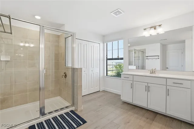 a bathroom with a shower sink and mirror