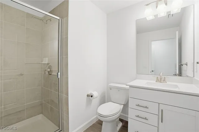 a bathroom with a sink toilet vanity and shower