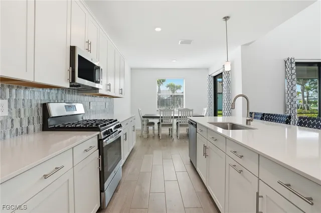 a kitchen with stainless steel appliances a sink stove and cabinets