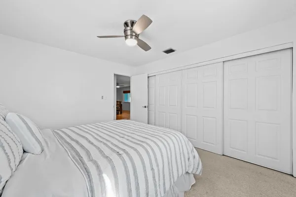 a bedroom with a large bed and a chandelier