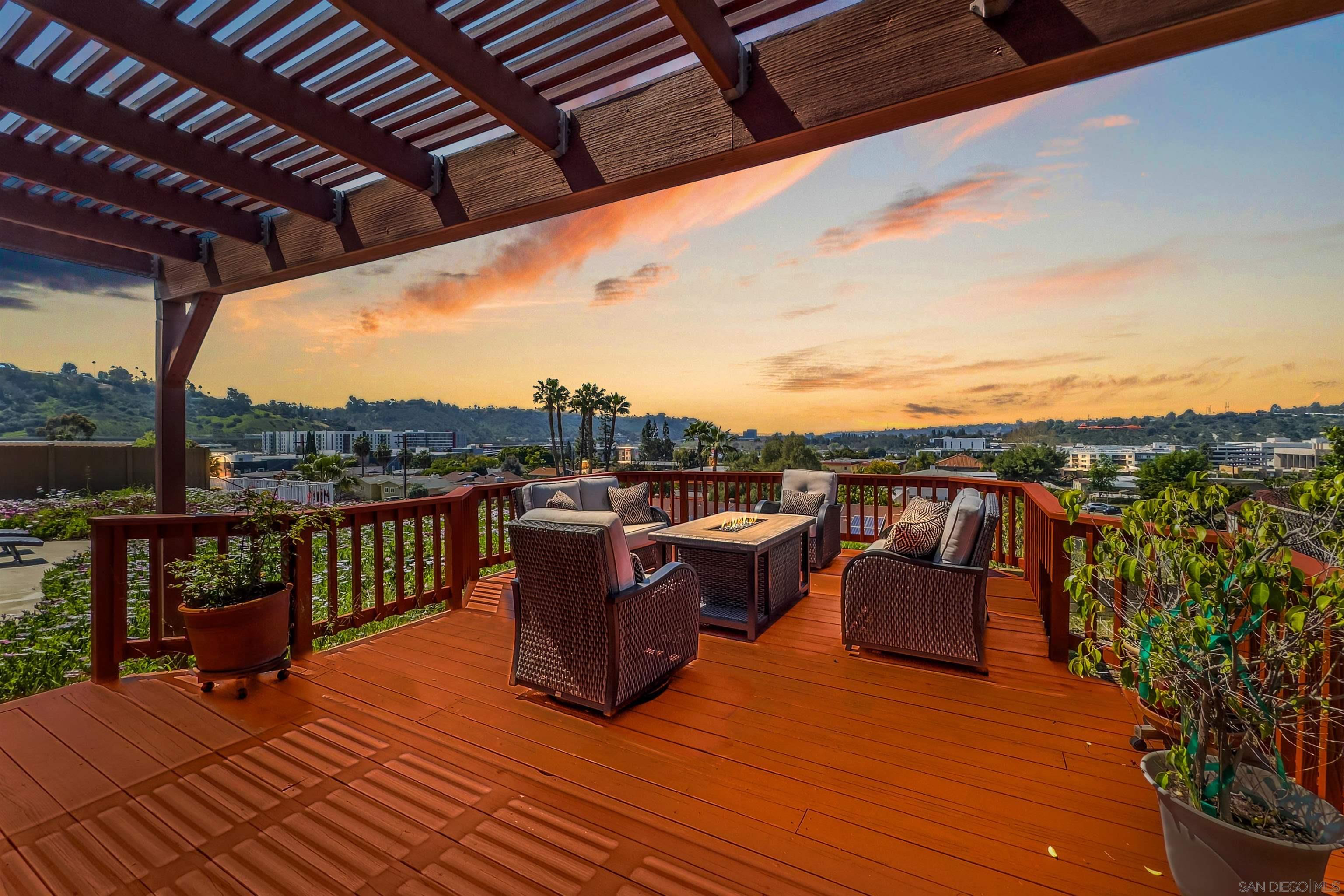 a view of a roof deck with couches and wooden floor
