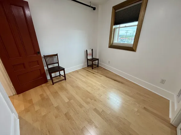 a view of a room with wooden floor and furniture