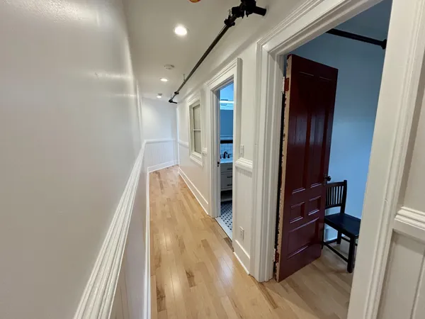 a view of a hallway with wooden floor and staircase