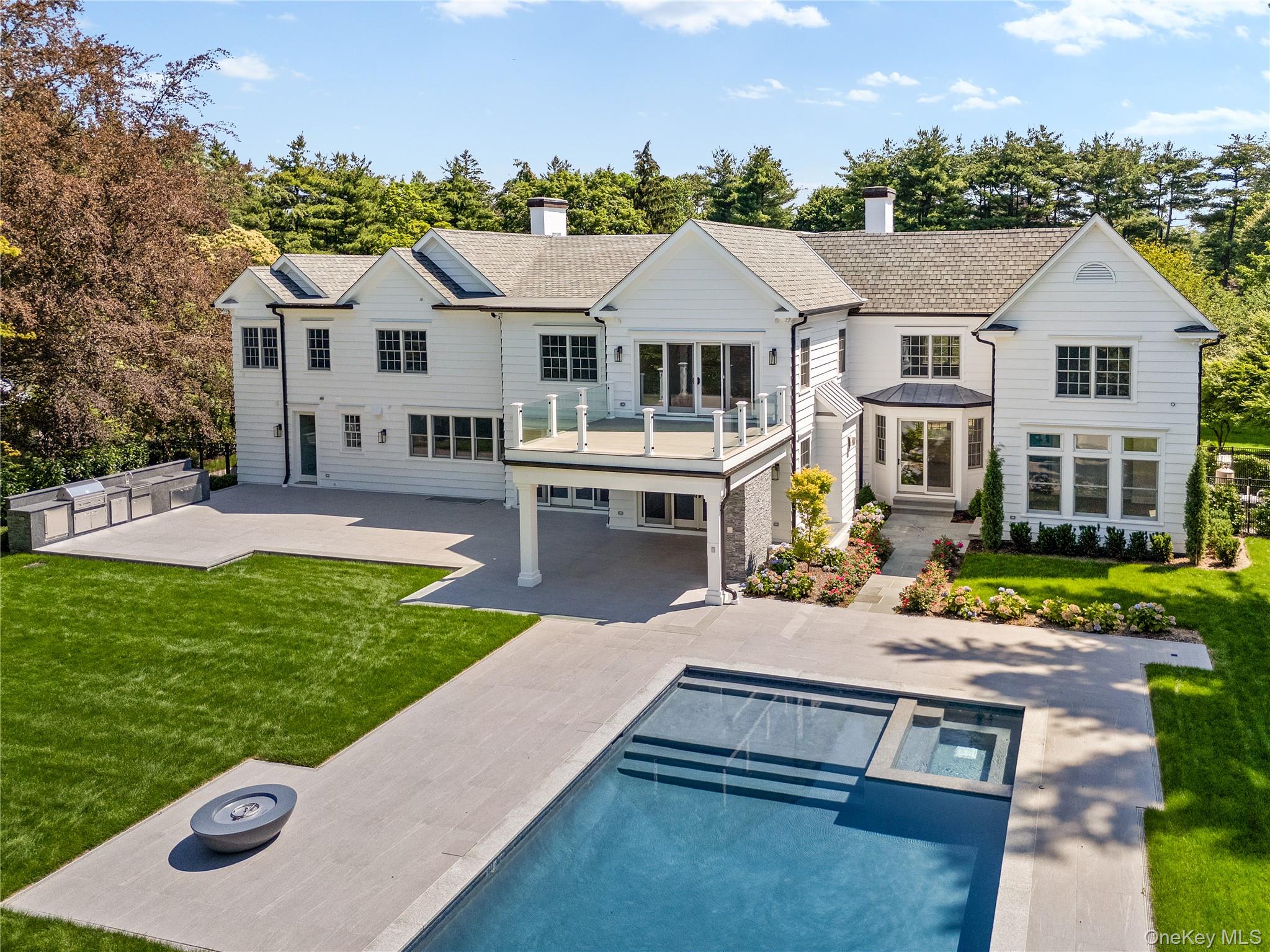 42 Mamaroneck Road Scarsdale, NY 10583 - Photo 4 of 47 The rear elevation reveals seamless indoor-outdoor living with multiple entertaining areas overlooking the sparkling pool and private grounds.