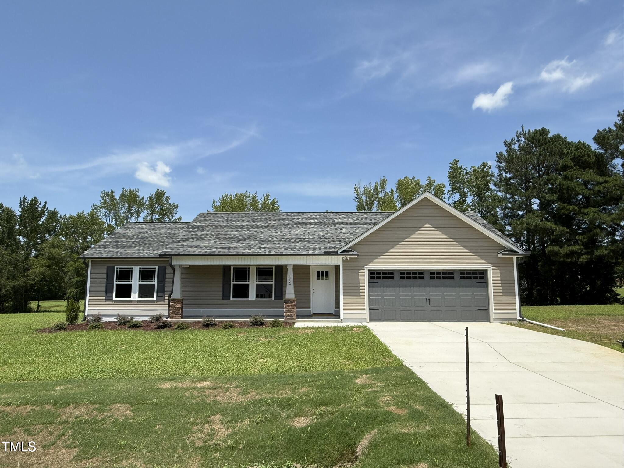 a front view of a house with a garden and yard