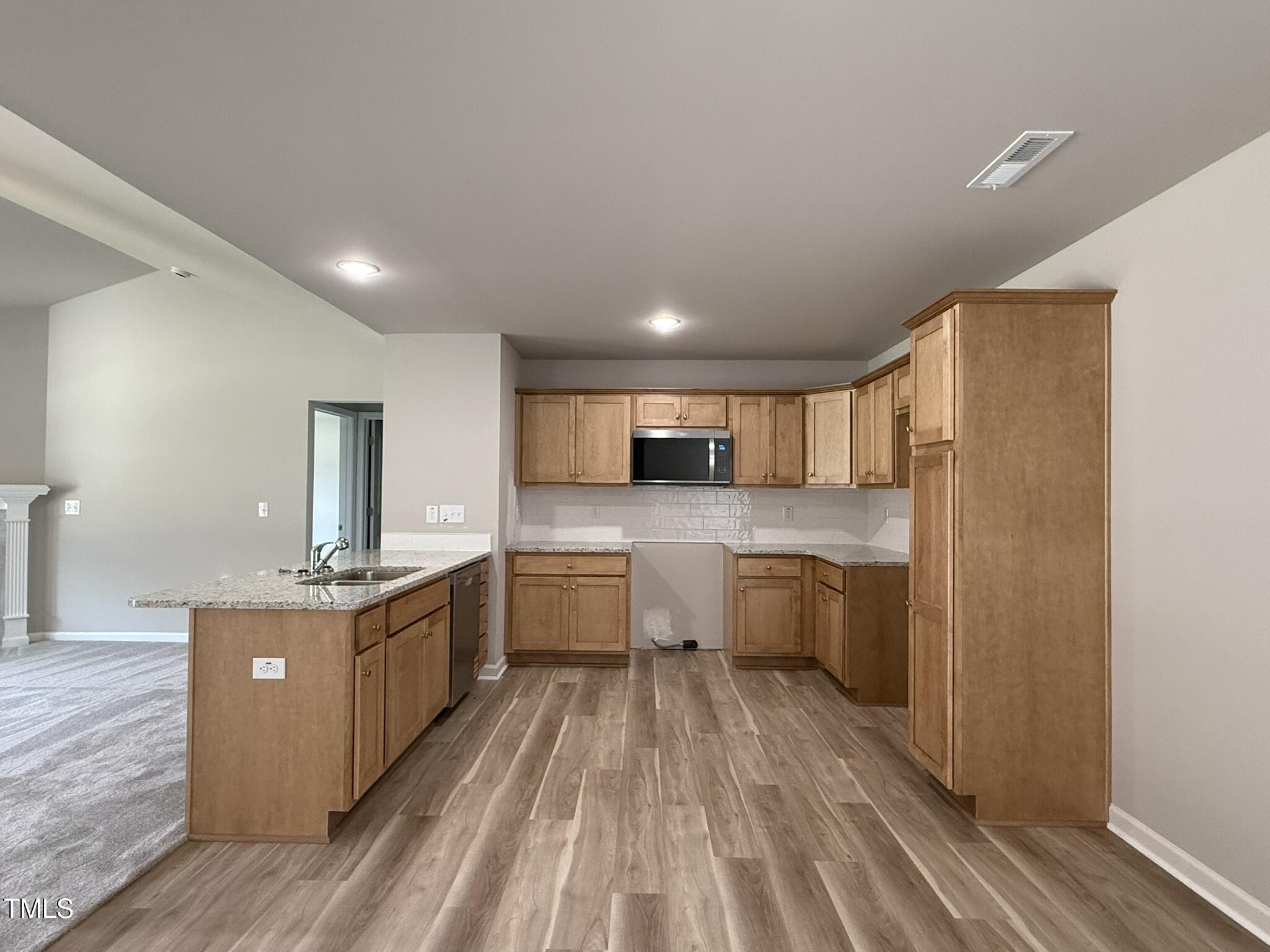 332 Magnolia Run Way Benson, NC 27504 - Photo 7 of 16 a kitchen with stainless steel appliances granite countertop a stove refrigerator and a sink
