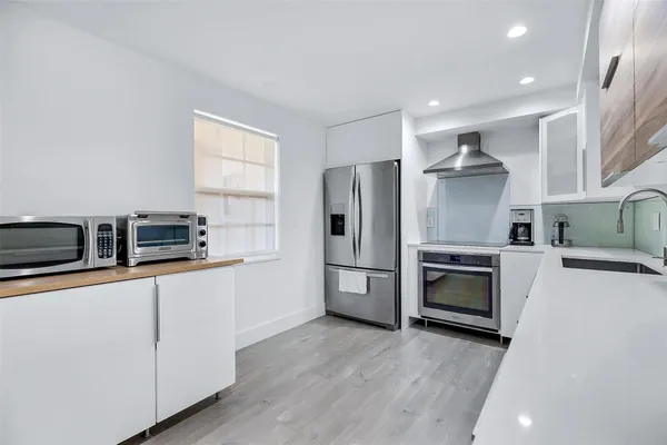 a kitchen with stainless steel appliances a refrigerator sink and microwave