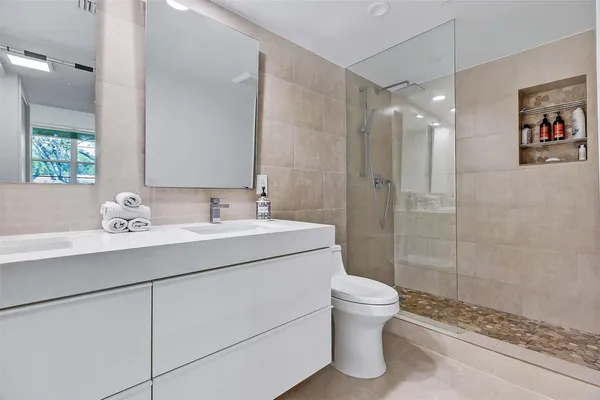a bathroom with a sink a toilet and shower