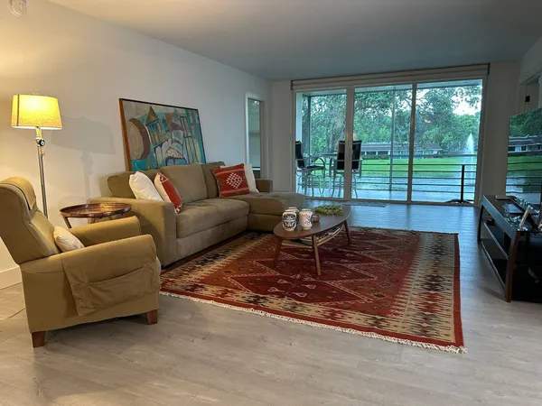 a living room with furniture floor to ceiling window and a floor to ceiling window