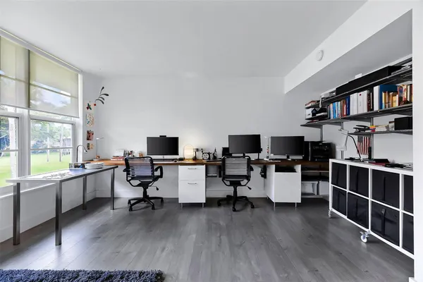 a work room with furniture a flat screen tv and a floor to ceiling window