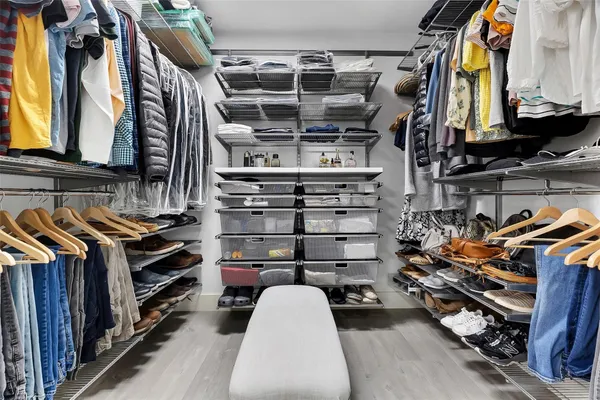 a view of walk in closet with clothes and shoes