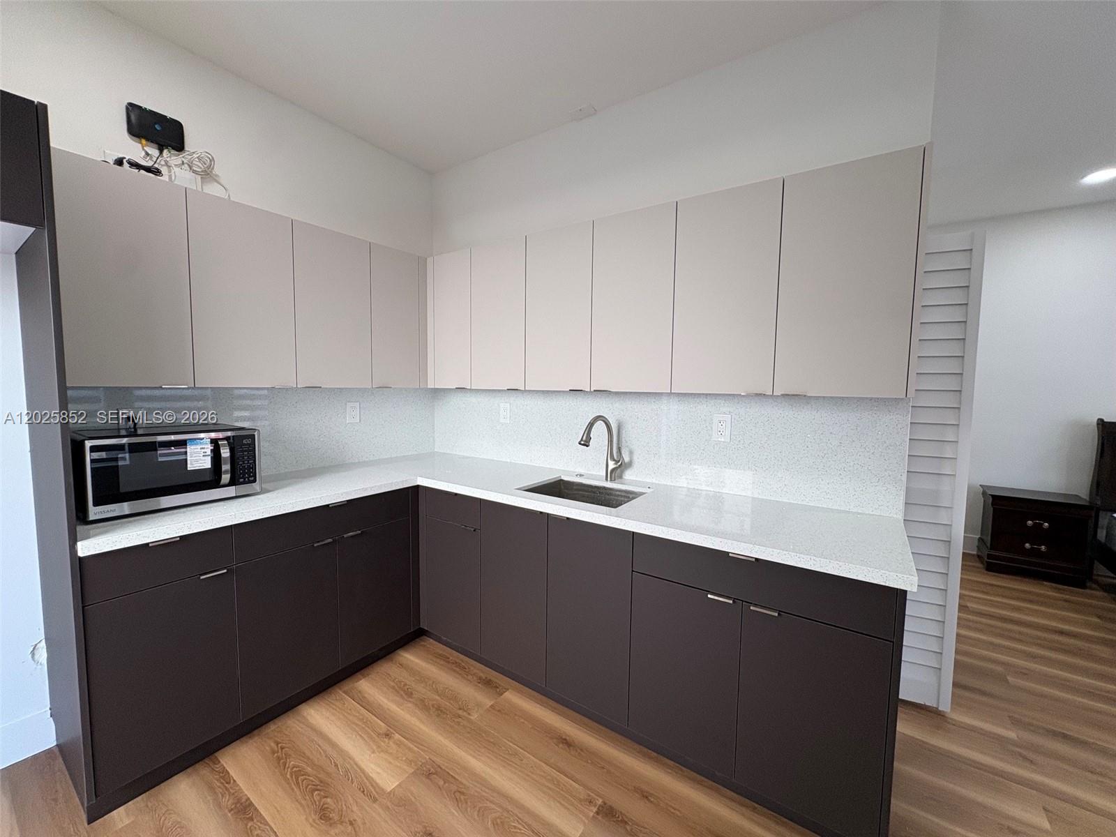 12948 Southwest 265th Terrace, Unit STUDIO Homestead, FL 33032 - Photo 8 of 16 a kitchen with a sink and cabinets