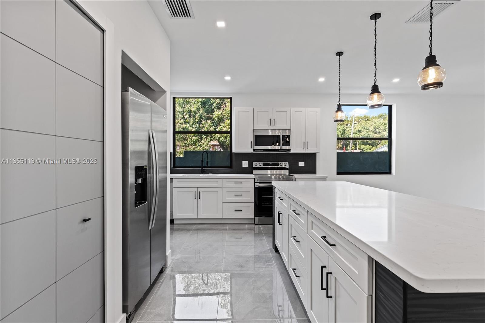3617 Southwest 27th Street Miami, FL 33133 - Photo 11 of 29 a kitchen with white cabinets and appliances