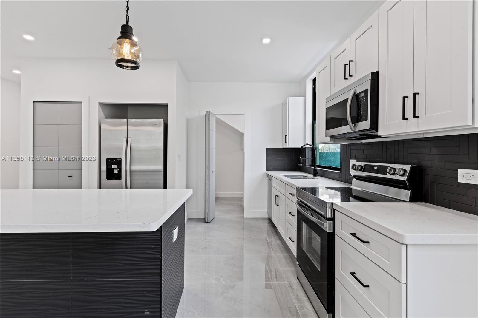 3617 Southwest 27th Street Miami, FL 33133 - Photo 13 of 29 a kitchen with stainless steel appliances a stove microwave and refrigerator