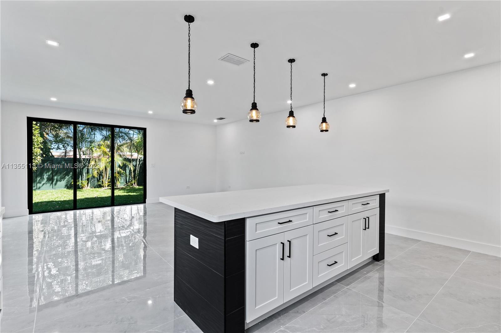3617 Southwest 27th Street Miami, FL 33133 - Photo 15 of 29 a kitchen with granite countertop white cabinets and window