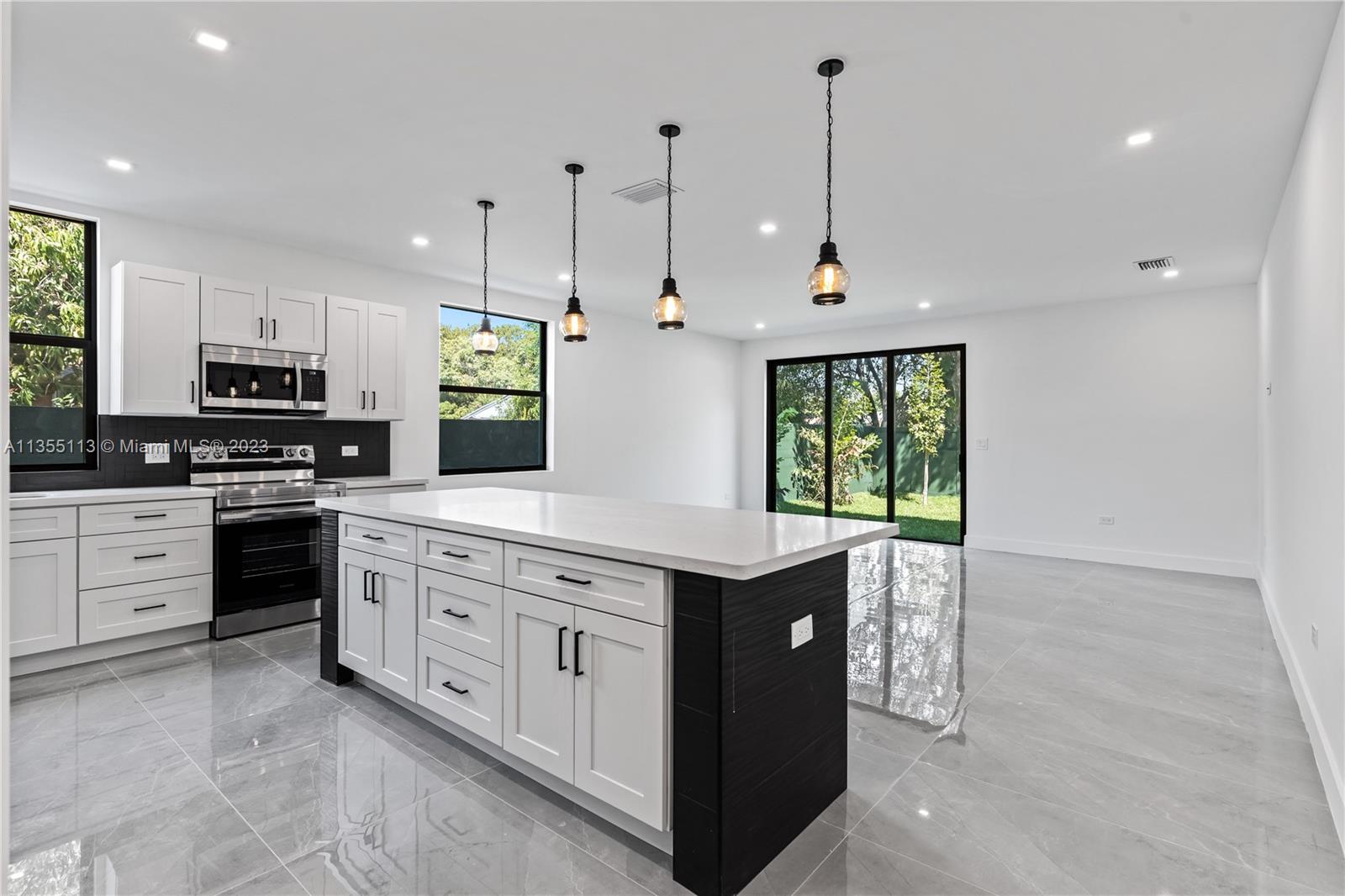 3617 Southwest 27th Street Miami, FL 33133 - Photo 10 of 29 a kitchen with stainless steel appliances kitchen island granite countertop a stove a sink and a refrigerator