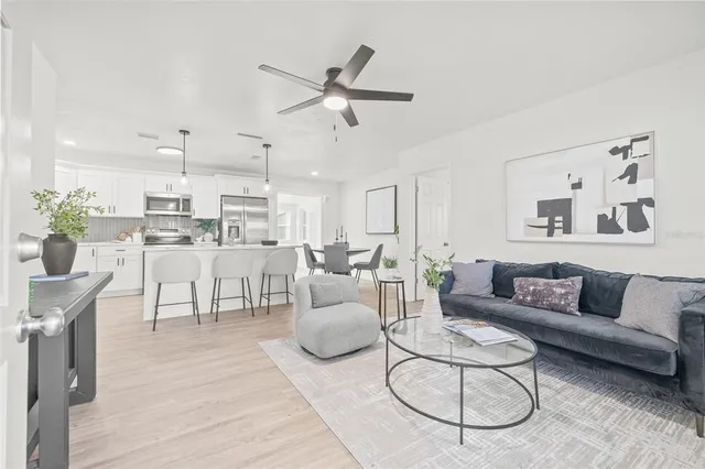 a living room with furniture a rug and kitchen view