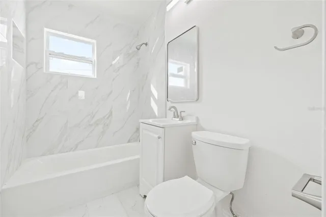 a white toilet sitting next to a bathroom sink and tub