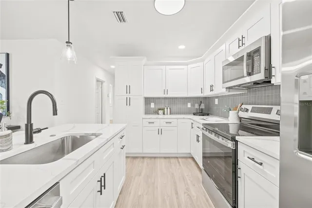 a kitchen with stainless steel appliances granite countertop a sink and cabinets