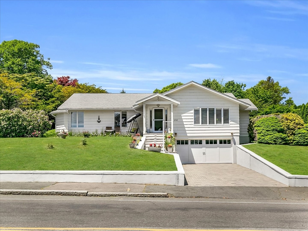 a front view of a house with a garden and yard