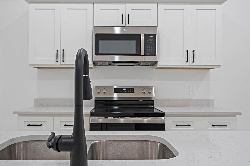 351 Edith Avenue Memphis, TN 38126 - Photo 4 of 15 Kitchen with appliances with stainless steel finishes, light stone countertops, and white cabinetry