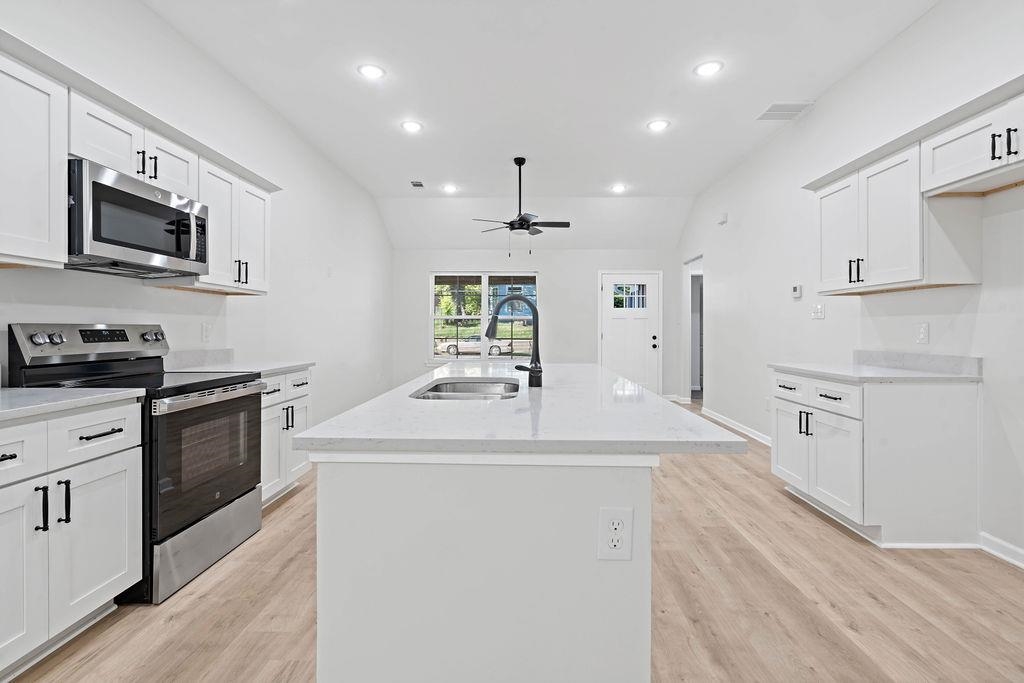 351 Edith Avenue Memphis, TN 38126 - Photo 5 of 15 Kitchen featuring appliances with stainless steel finishes, white cabinets, lofted ceiling, recessed lighting, and light wood finished floors