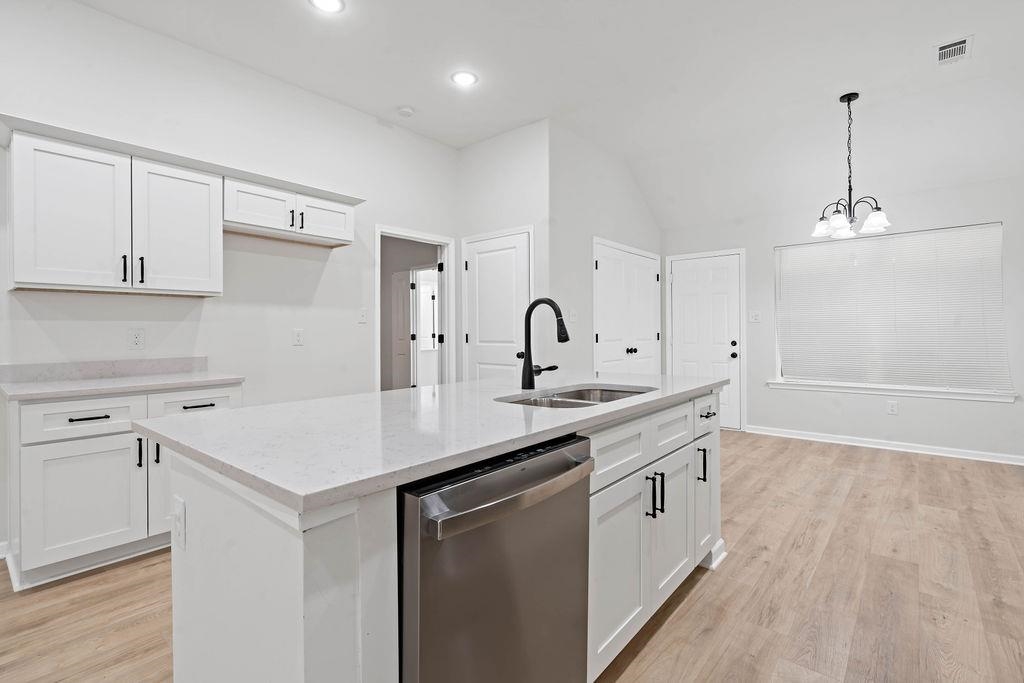 351 Edith Avenue Memphis, TN 38126 - Photo 6 of 15 Kitchen featuring light wood finished floors, stainless steel dishwasher, white cabinets, vaulted ceiling, and recessed lighting