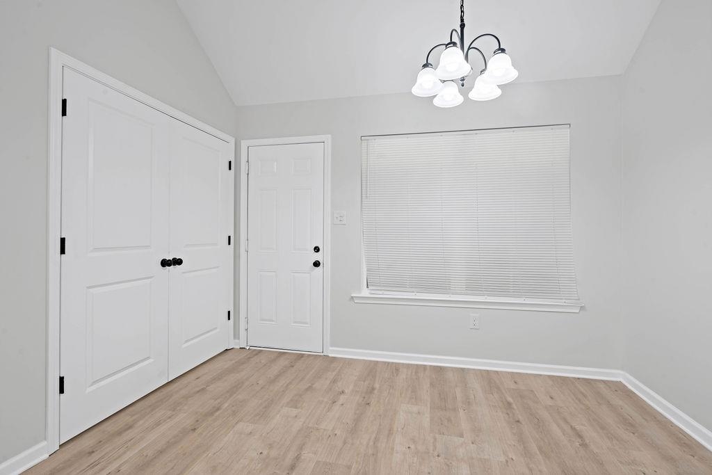 351 Edith Avenue Memphis, TN 38126 - Photo 9 of 15 Unfurnished dining area with light wood-style flooring, vaulted ceiling, and a chandelier