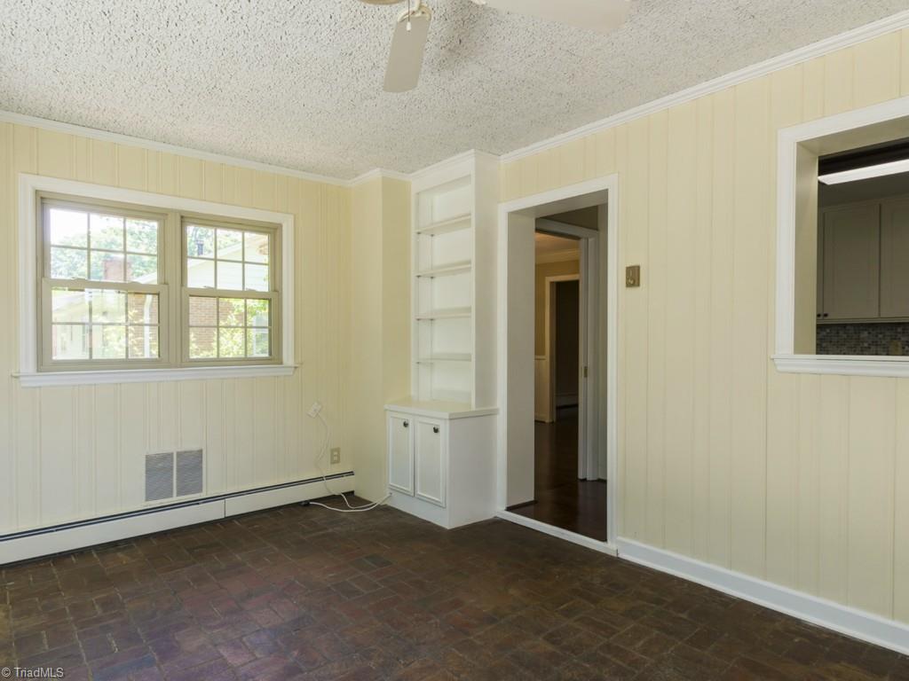 3612 Pinetop Road Greensboro, NC 27410 - Photo 11 of 30 Showing you the built-in shelving and storage in the sunroom.