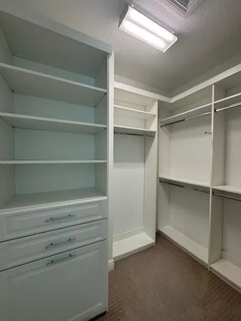 a view of walk in closet with empty racks