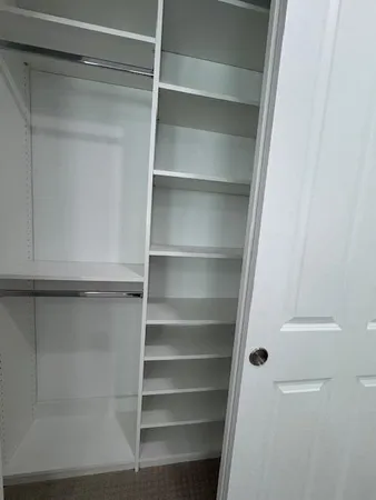 a view of walk in closet with empty racks