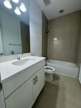 a bathroom with a granite countertop sink a toilet a mirror and shower