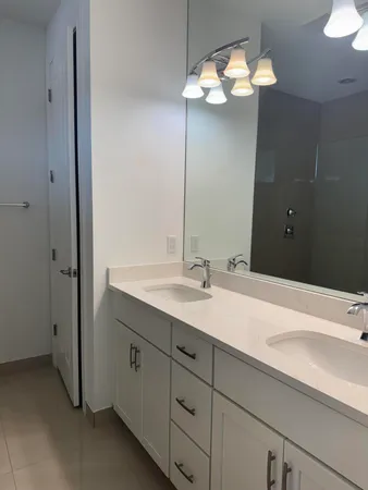 a bathroom with a sink a light fixture and a mirror