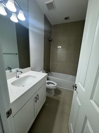 a bathroom with a double vanity sink toilet and shower